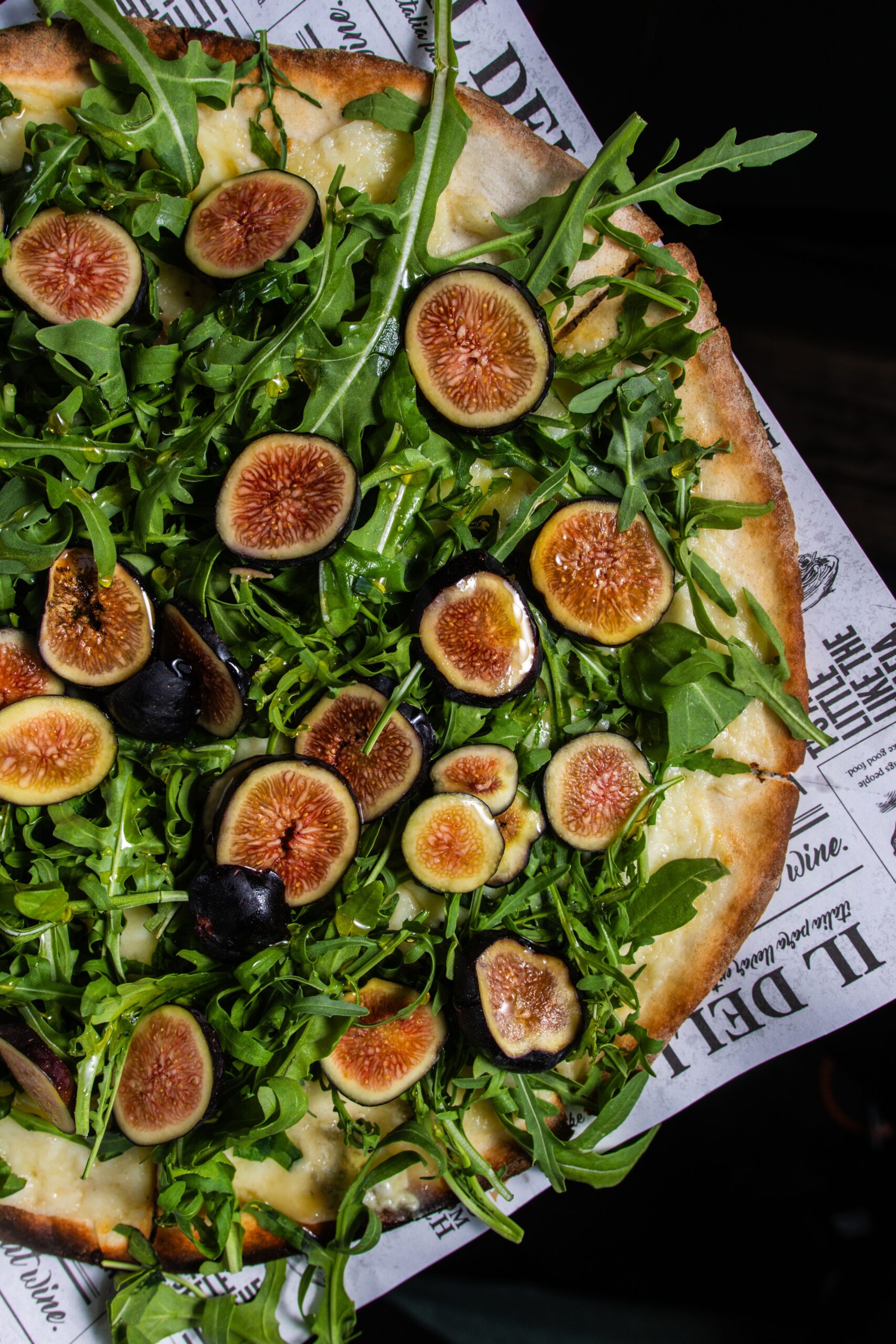 Delicious fig and arugula pizza showcasing fresh ingredients in a top view shot.