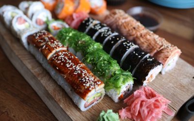 A delicious selection of sushi rolls with toppings like seaweed and sesame seeds on a wooden platter.